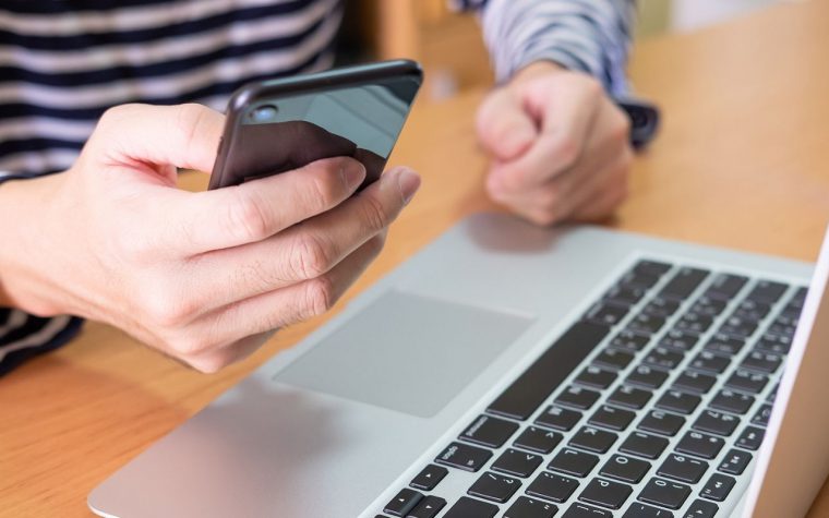 man on phone in front of laptop